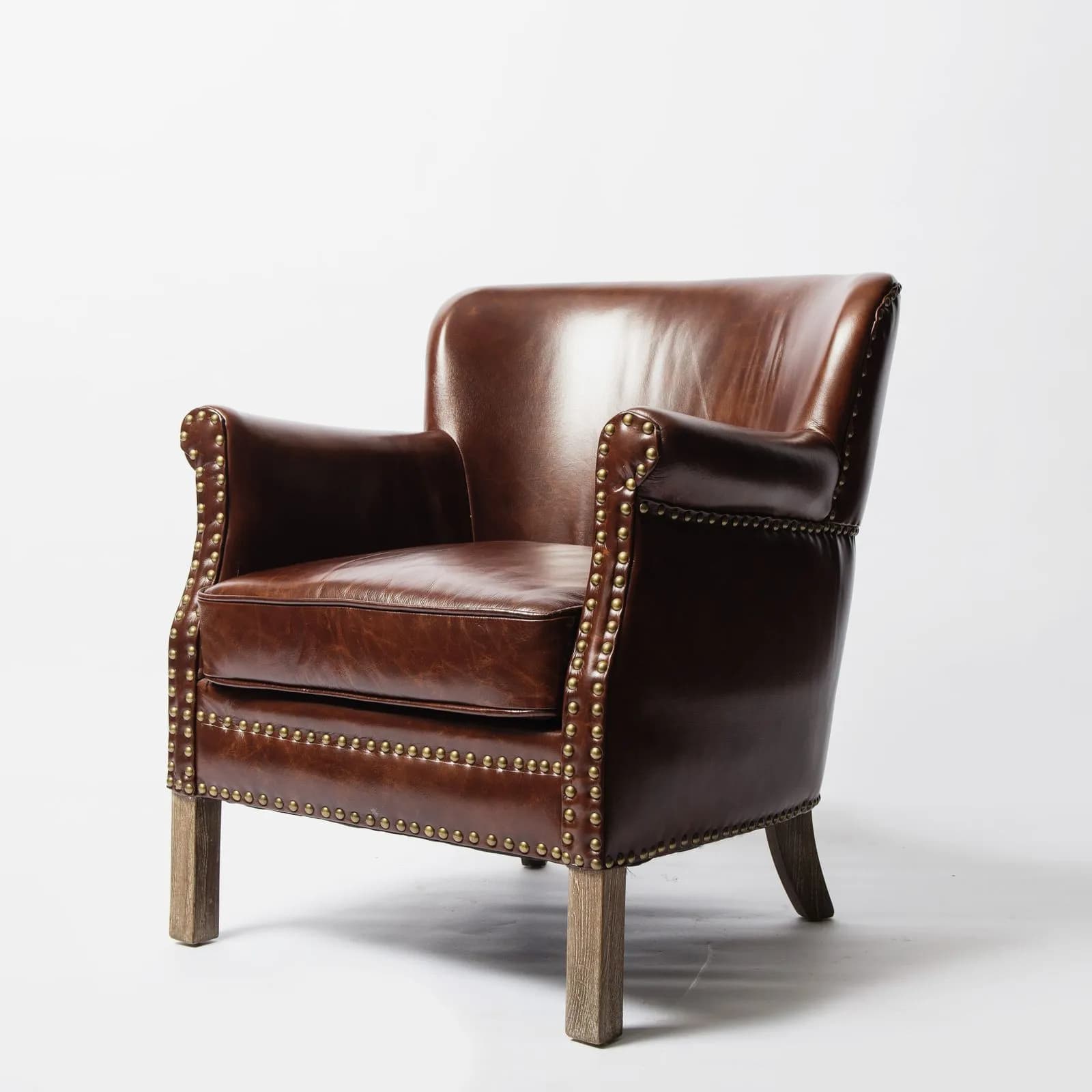 Poltrona de couro caramelo com tachas, vista lateral