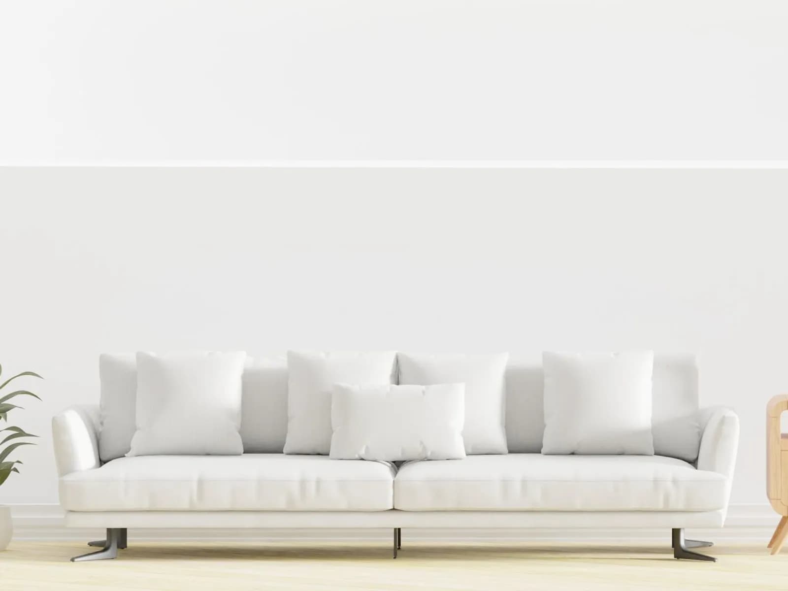 Sofá branco de três lugares com almofadas soltas em sala clara