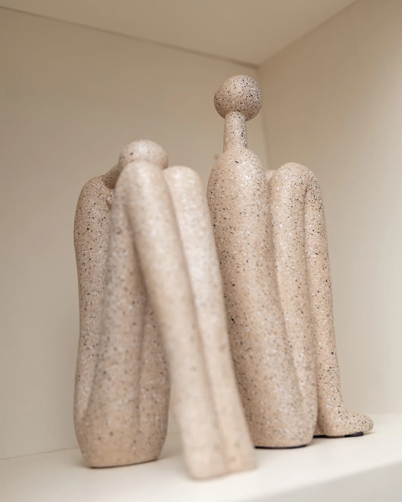 Esculturas de pedra em formas orgânicas sobre prateleira